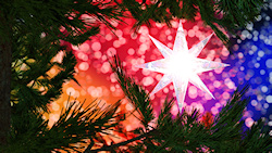 A bright star hanging in a Christmas tree against a sparkling bokeh background in all the colors of the rainbow....