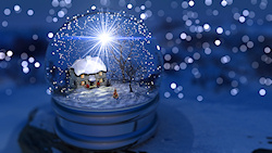 Inside a snow globe is a winter landscape with a cottage overshadowed by bare maple and cherry trees. In the windows of the little house candles burn,...